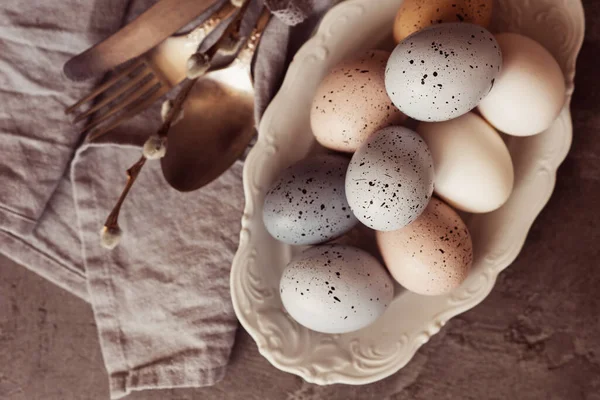 Koyu ahşap arka planda Paskalya yumurtaları olan klasik mutfak gereçleri. Kopyalama alanı olan üst görünüm.
