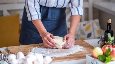 Kadın para kazanıyor. Hamur, mutfak masasındaki kompozisyonda pişirmek için aksesuar ve un..