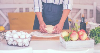 Kadın para kazanıyor. Hamur, mutfak masasındaki kompozisyonda pişirmek için aksesuar ve un..