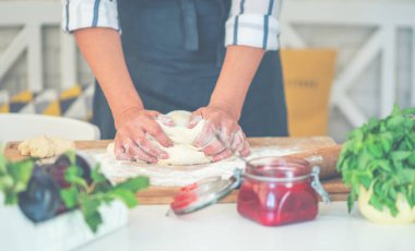 Kadın para kazanıyor. Hamur, mutfak masasındaki kompozisyonda pişirmek için aksesuar ve un..