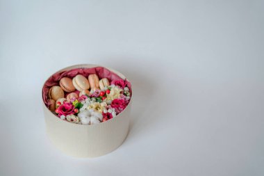 Gri arkaplanlı çiçek ve Fransız kurabiyeleriyle birlikte hediye ya da hediye. Kırsal tarzda. Tonu ayarlanmış resim.