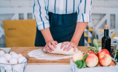 Kadın para kazanıyor. Hamur, mutfak masasındaki kompozisyonda pişirmek için aksesuar ve un..