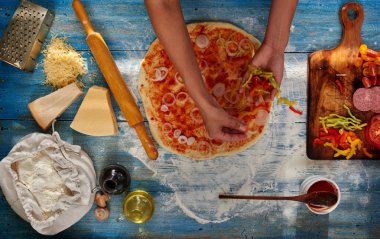 O pizza için malzemeler koyar