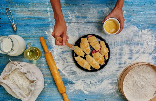 Kvinnlig hand smörjer bagels med äggula — Stockfoto
