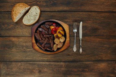 Fırında bir seramik pişirme çanağı içinde yatan et parçalar halinde kesilmiş