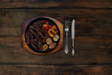 Fırında bir seramik pişirme çanağı içinde yatan et parçalar halinde kesilmiş