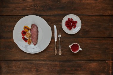 İki kızarmış biftek yalan büyük bir beyaz tabak üzerine