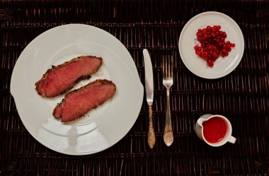 İki kızarmış biftek yalan büyük bir beyaz tabak üzerine