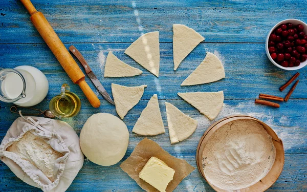 On the wooden kitchen table is sliced dough — 图库照片