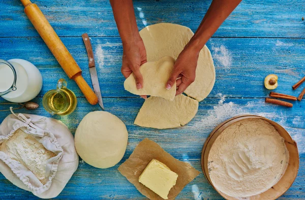 Dona de casa corta a massa em pedaços forma triangular — Fotografia de Stock