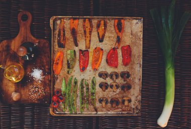 There are vegetables carefully arranged on a baking sheet
