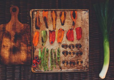 There are vegetables carefully arranged on a baking sheet