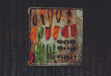 There are vegetables carefully arranged on a baking sheet