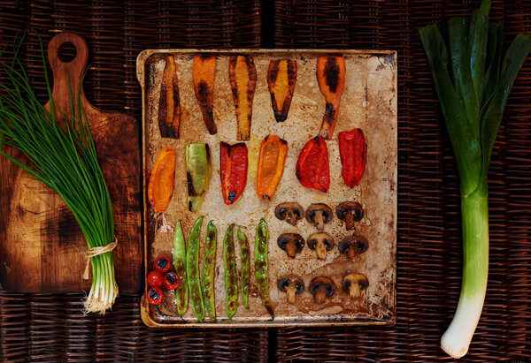 There are vegetables carefully arranged on a baking sheet