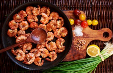 Bir dökme demir tavada karides vardır