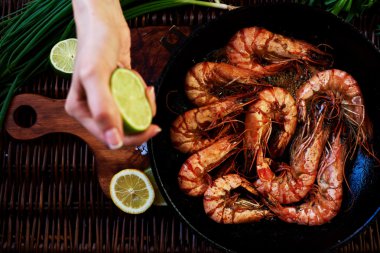 Girl chef squeezes out lime shrimp