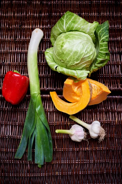 There are vegetables on a dark rattan table