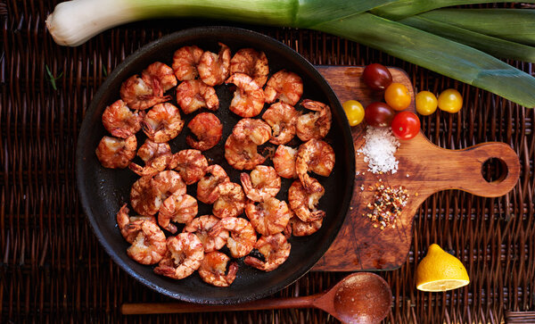 There are shrimps in a cast iron skillet