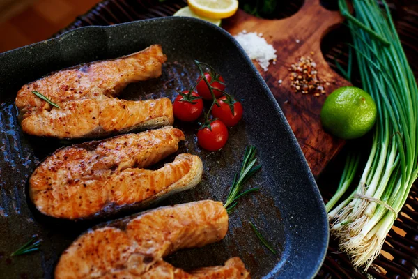 There are several salmon steak on the grill pan