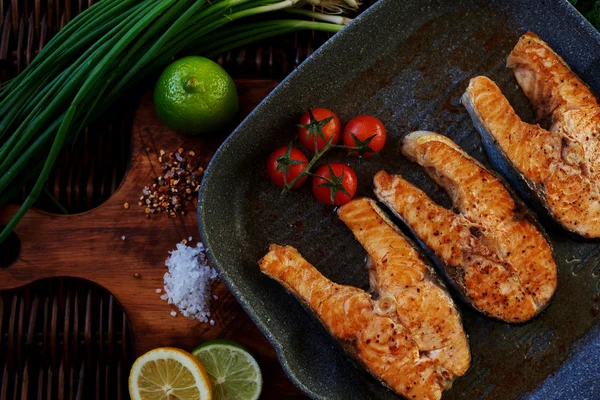 There are several salmon steak on the grill pan