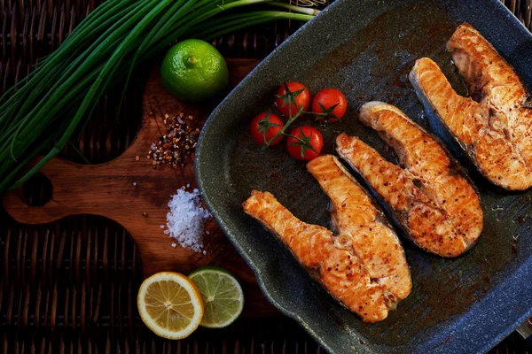 There are several salmon steak on the grill pan