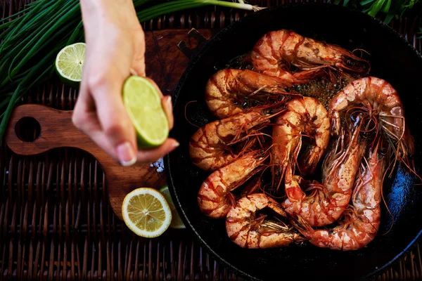 Girl chef squeezes out lime shrimp — Stockfoto