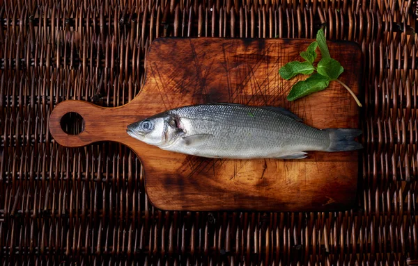 На дерев'яній дошці є свіжа риба — стокове фото