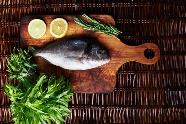 Il y a du poisson frais sur une planche de bois — Photo