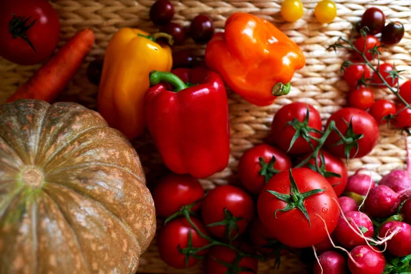 На столі ротанга є асортимент свіжих овочів — стокове фото