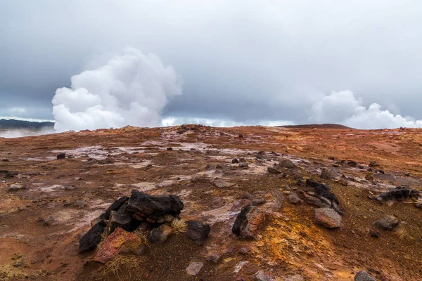 İzlanda 'da jeotermal alan. Hiç kimse. Turuncu zeminin üzerinde güçlü bir buhar jeti ve bulutlu bir gökyüzü. Reykjanes Yarımadası
