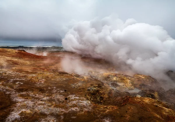 İzlanda 'da jeotermal alan. Hiç kimse. Turuncu zeminin üzerinde güçlü bir buhar jeti ve bulutlu bir gökyüzü. Reykjanes Yarımadası