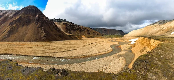Landmannalaugar İzlanda 'nın turuncu kayalıkları arasında geniş bir vadi ve nehir manzarası
