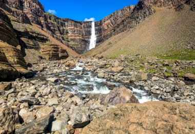 Nehir, taşlar ve şelale dağlarda kayaların arasında. İzlanda