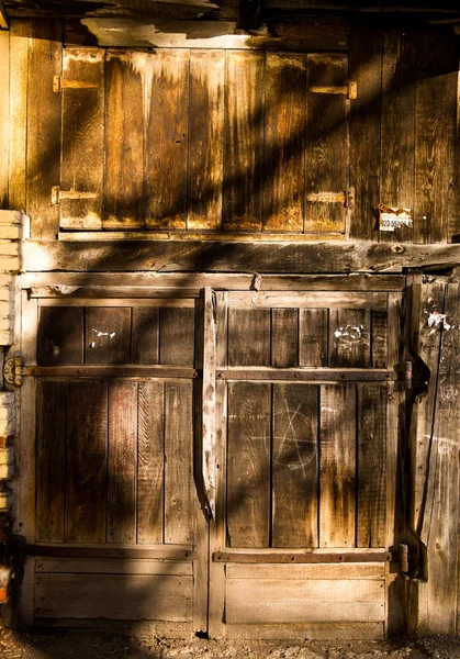 Antigua puerta de garaje de madera con sombras de las ramas del árbol —  Fotos de Stock