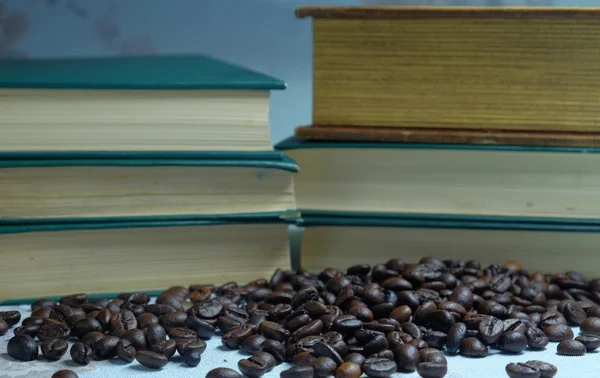 Coffee beans in the background of a closed books — Stock Photo, Image