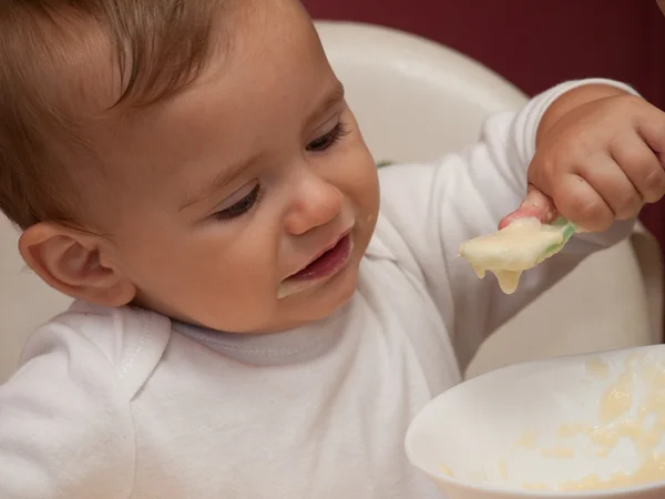 Criança comendo e segurando colher — Fotografia de Stock