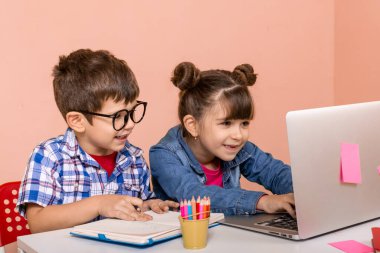 Çocuklar evde çevrimiçi öğreniyorlar. Çocuklar için ev eğitimi ve uzaktan eğitim. Kız ve öğrenci çevrimiçi video öğretmeniyle çalışıyor