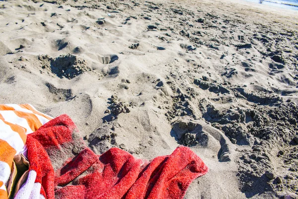 ผ้าขนหนูมุมกว้างบนชายหาด พร้อมหมวกและแว่นกันแดด . — ภาพถ่ายสต็อก
