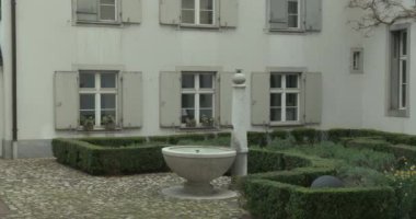 Martinsgasse üzerinden çeşmeli bir avlu manzarası