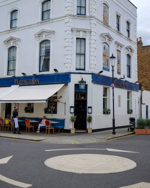 London - 06 25 2022: Manager and guest at The Abingdon pub at the junction of Abingdon Road and Abingdon Villas