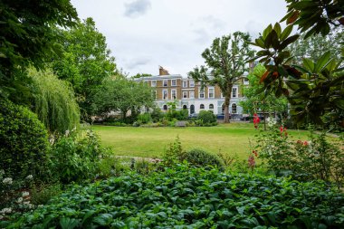 Londra - 06 29 2022: Arka planda evleri olan Saint James 's Gardens manzarası