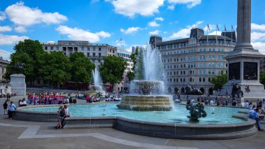 Londra - 07 08 2022: Trafalgar Meydanı 'ndaki çeşmenin manzarası ve Nelson Sütununun tabanı