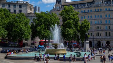 Londra - 07 08 2022: Trafalgar Meydanı 'ndaki çeşmenin turistlerle manzarası.