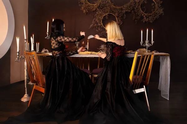 İki cadı sihirli bir aşk büyüsü yapıyor. Sihir. Fantezi güzel kızlar karanlık bir gotik odada bir cadı suretinde. Sihir, fantezi, Cadılar Bayramı