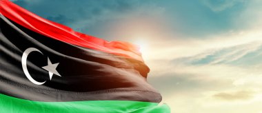 Libya ulusal bayrağı güzel bulutlarda dalgalanıyor.