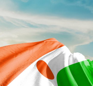 Güzel bulutlarda sallanan Nijer ulusal bayrağı.