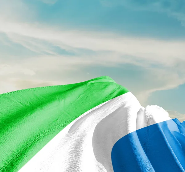 塞拉利昂国旗在美丽的云彩中飘扬 — 图库照片