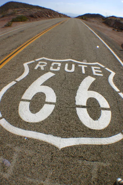 Malba na silnici oznamuje, že je to Route 66, která se táhne k obzoru — Stock fotografie