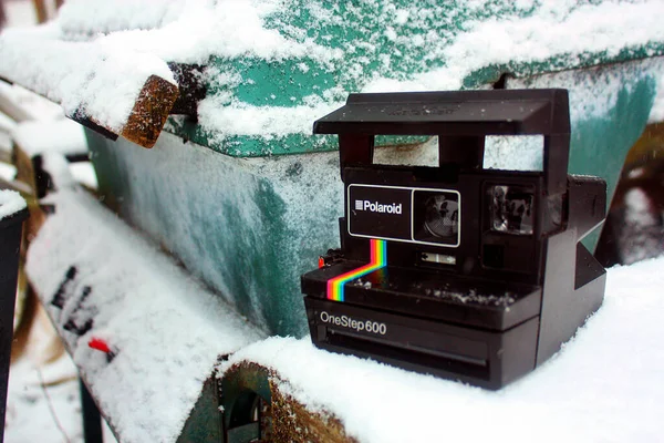 Un Polaroid One Step 600 se trouve près d'un récipient en métal sarcelle recouvert de neige — Photo