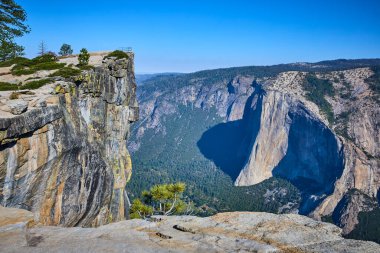 Taft Point 'in güneşli granit kayalıkları görkemli El Capitan' a ve Yosemite Ulusal Parkı 'ndaki yemyeşil orman vadisine bakar. Kaliforniya maceranın ve doğal harikanın özünü yakalar..